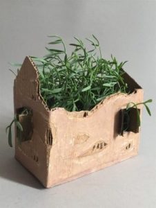 Cardboard box made to look like a house with mistletoe inside