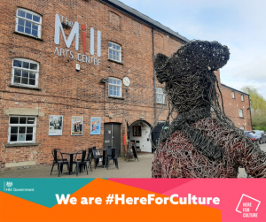 Exterior of The Mill Arts Centre with a banner reading 'We are #HereForCulture'