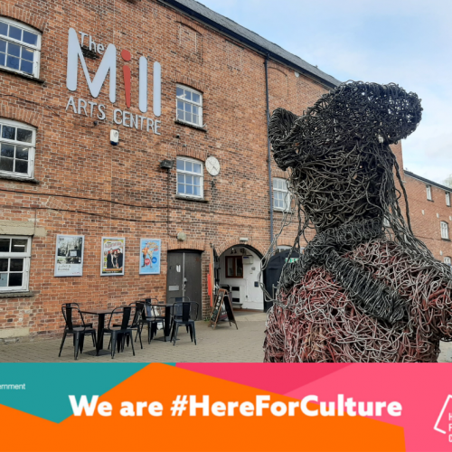 Exterior of The Mill Arts Centre with a banner reading 'We are #HereForCulture'