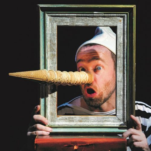 Pinocchio looks out from a picture frame with along nose made of ice cream cones