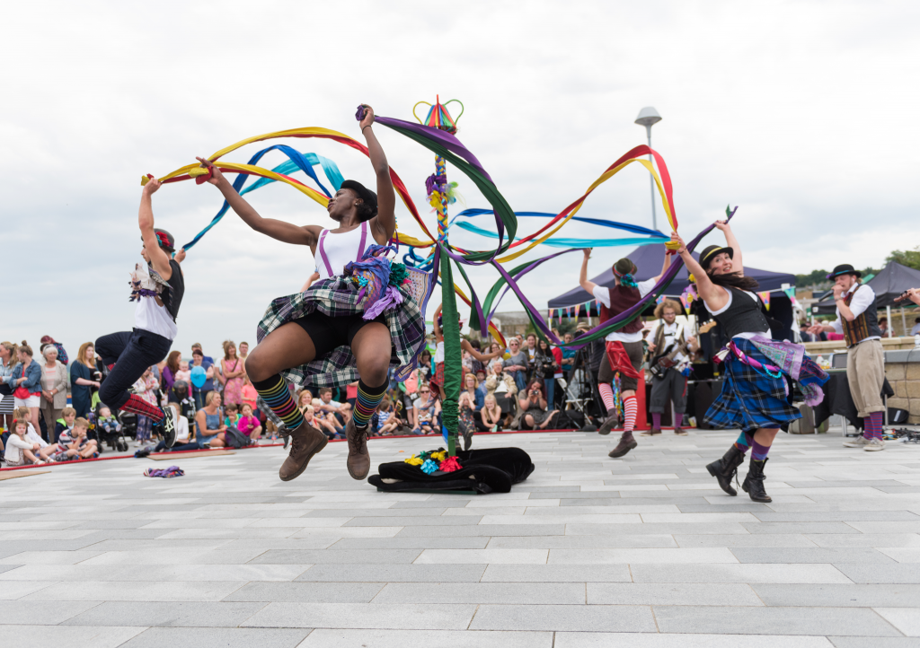 Dancers leap around a maypole